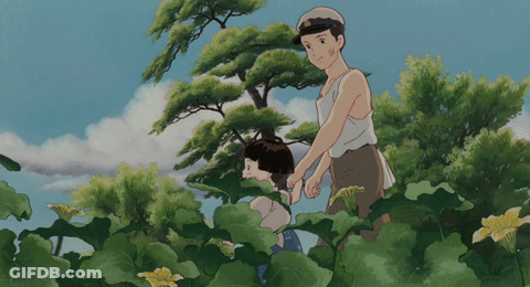 A Man And A Woman Are Standing In A Field Of Plants GIF