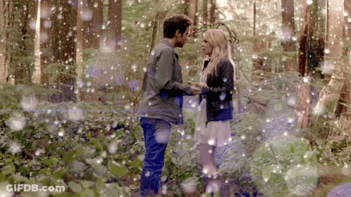 Man And Woman Standing In Snowy Forest GIF