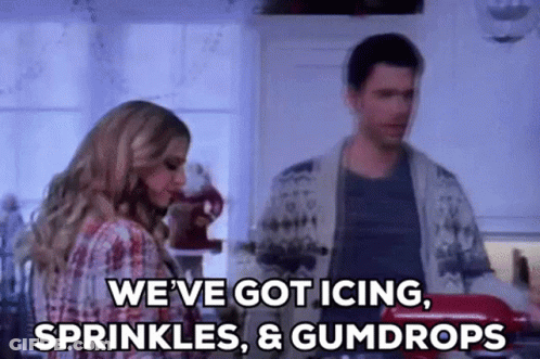 A Man And A Woman Are Standing In A Kitchen And The Woman Is Saying `` We 'Ve Got Icing , Sprinkles GIF