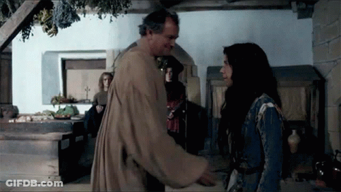 A Man And A Woman Are Standing In A Room Talking To Each Other GIF