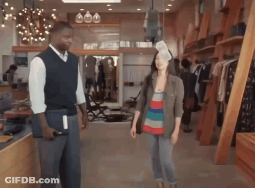 A Man And A Woman Are Standing In A Store GIF