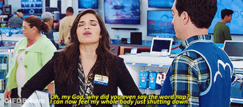 A Man And A Woman Are Standing In A Store Talking . GIF
