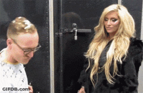 A Man And A Woman Are Standing In Front Of A Black Door GIF