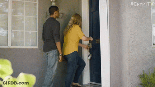 A Man And A Woman Are Standing In Front Of A Blue Door With #Crypttv Written On The Bottom Right GIF