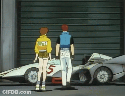 A Man And A Woman Are Standing In Front Of A Car With The Number 5 On It GIF