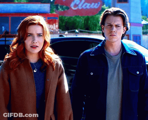 A Man And A Woman Are Standing In Front Of A Claw Restaurant GIF