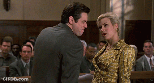 A Man And A Woman Are Standing In Front Of A Crowd In A Court Room GIF