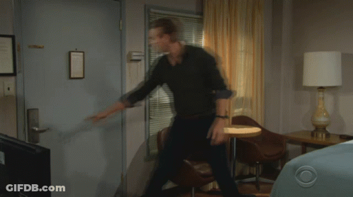 A Man And A Woman Are Standing In Front Of A Door With The Number 1136 On It GIF