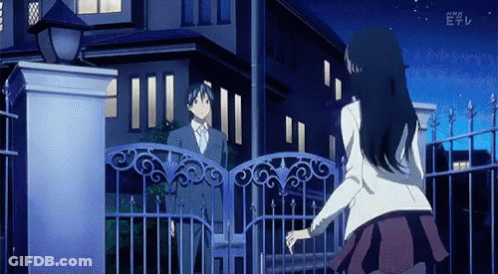 A Man And A Woman Are Standing In Front Of A Fence With The Letters E On The Bottom Left GIF