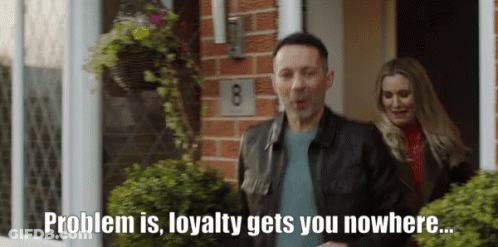 A Man And A Woman Are Standing In Front Of A House With The Number 8 On The Brick Wall GIF