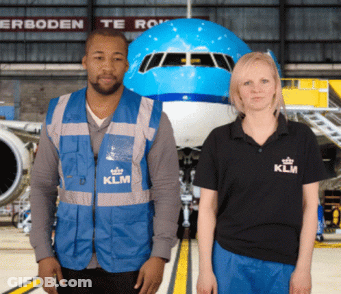 A Man And A Woman Are Standing In Front Of A Klm Airplane GIF