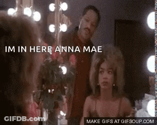 A Man And A Woman Are Standing In Front Of A Mirror . The Woman Is Looking At Herself In The Mirror . GIF
