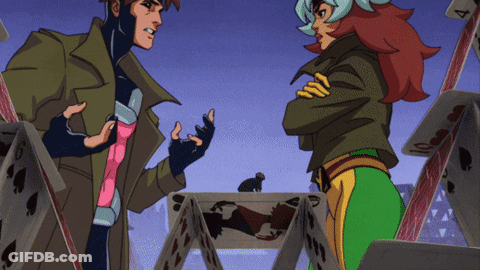 A Man And A Woman Are Standing In Front Of A Pile Of Playing Cards One Of Which Has The Number 4 On It GIF