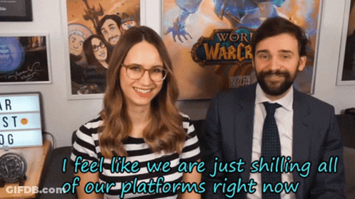 A Man And A Woman Are Standing In Front Of A Poster For World Of Warcraft GIF