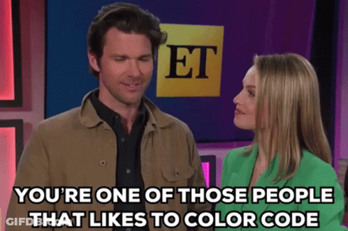 A Man And A Woman Are Standing In Front Of A Sign That Says Et On It GIF