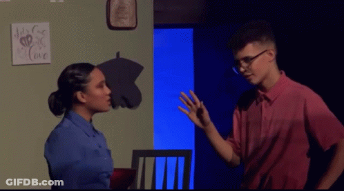 A Man And A Woman Are Standing In Front Of A Sign That Says " It 'S For Love " GIF