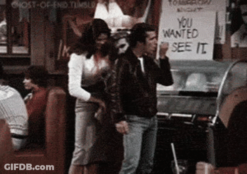 A Man And A Woman Are Standing In Front Of A Sign That Says " You Wanted See It " GIF