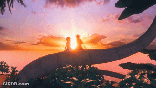 A Man And A Woman Are Standing In Front Of A Sunset GIF