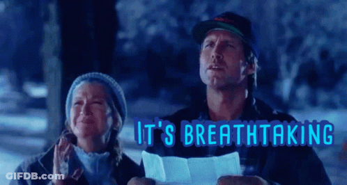 A Man And A Woman Are Standing In The Snow With The Words It 'S Breathtaking Behind Them GIF