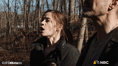 A Man And A Woman Are Standing In The Woods With A Nbc Logo On The Bottom GIF