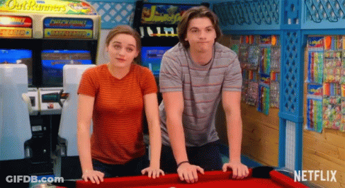 A Man And A Woman Are Standing Next To A Pool Table With Netflix Written On It GIF