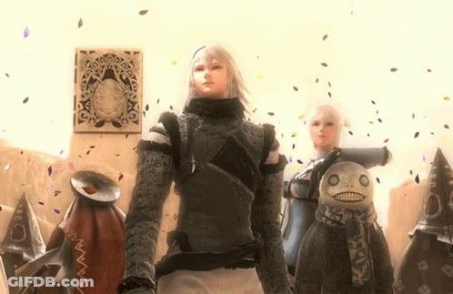 A Man And A Woman Are Standing Next To A Stuffed Animal GIF