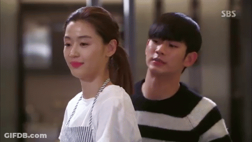 A Man And A Woman Are Standing Next To Each Other . GIF