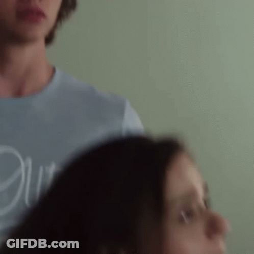 A Man And A Woman Are Standing Next To Each Other . GIF