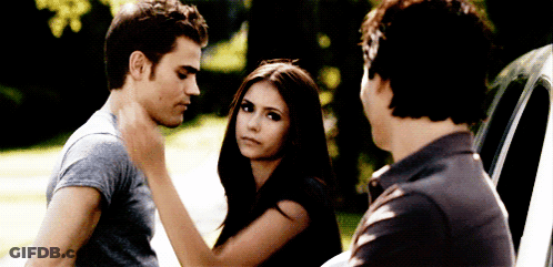 A Man And A Woman Are Standing Next To Each Other And A Man Is Touching The Woman 'S Neck GIF