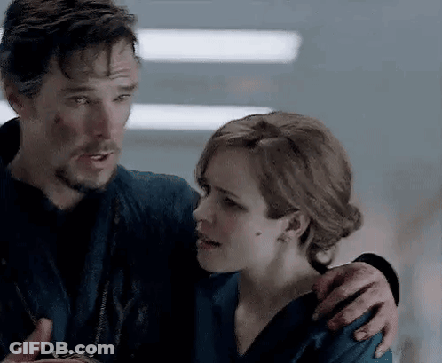 A Man And A Woman Are Standing Next To Each Other And Hugging . GIF