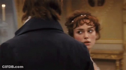 A Man And A Woman Are Standing Next To Each Other And Looking At Each Other . GIF