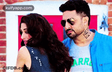 A Man And A Woman Are Standing Next To Each Other And Looking At Each Other . GIF