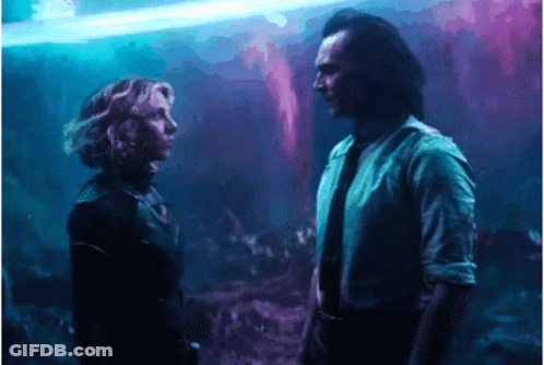 A Man And A Woman Are Standing Next To Each Other And Looking At Each Other . GIF