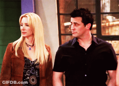 A Man And A Woman Are Standing Next To Each Other And Looking At Each Other GIF