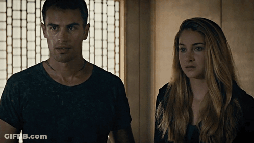 A Man And A Woman Are Standing Next To Each Other And Looking At The Camera GIF