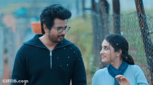 A Man And A Woman Are Standing Next To Each Other And Smiling GIF