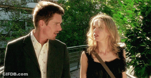 A Man And A Woman Are Standing Next To Each Other And Talking GIF