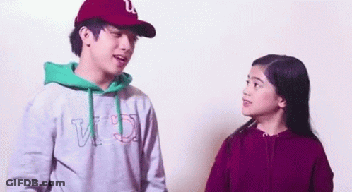 A Man And A Woman Are Standing Next To Each Other And Talking To Each Other . GIF