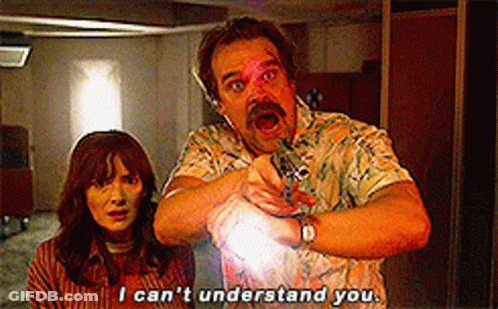 A Man And A Woman Are Standing Next To Each Other And The Man Is Pointing At The Woman . GIF
