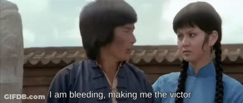 A Man And A Woman Are Standing Next To Each Other And The Man Is Saying I Am Bleeding Making Me The Victor GIF