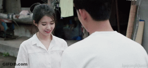 A Man And A Woman Are Standing Next To Each Other And The Man Is Smiling GIF