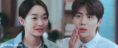 A Man And A Woman Are Standing Next To Each Other And The Man Is Touching The Woman 'S Face . GIF