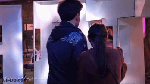 A Man And A Woman Are Standing Next To Each Other And The Man Is Wearing A Blue Jacket GIF