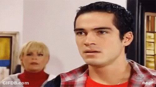 A Man And A Woman Are Standing Next To Each Other And The Man Is Wearing A Red Shirt GIF