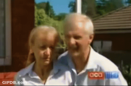 A Man And A Woman Are Standing Next To Each Other And The Man Is Wearing A Shirt That Says Acca GIF