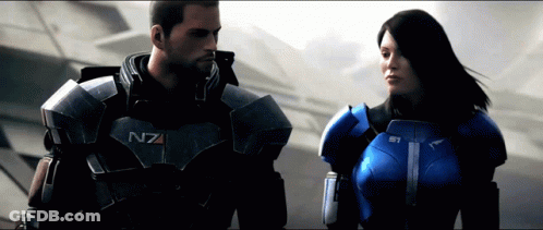 A Man And A Woman Are Standing Next To Each Other And The Man 'S Armor Says N7 On It GIF