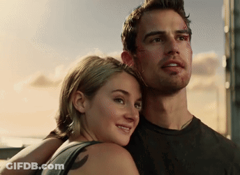 A Man And A Woman Are Standing Next To Each Other And The Woman Has A Tattoo On Her Back GIF