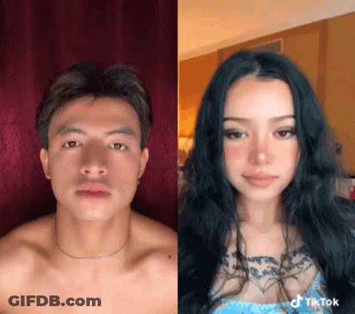 A Man And A Woman Are Standing Next To Each Other And The Woman Has A Tattoo On Her Chest GIF