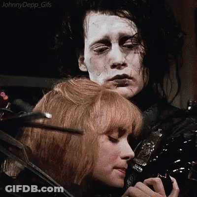 A Man And A Woman Are Standing Next To Each Other And The Woman Is Holding The Man 'S Hair . GIF