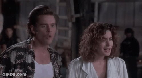 A Man And A Woman Are Standing Next To Each Other And The Woman Is Making A Face . GIF